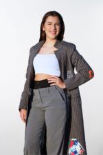 Mujer con abrigo largo gris de rayas y detalles ilustrados