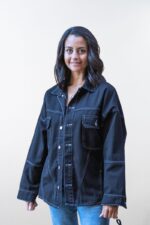 Vista frontal de chaqueta oversize negra con costuras blancas