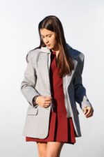 Mujer usando blazer largo gris con capucha, de frente