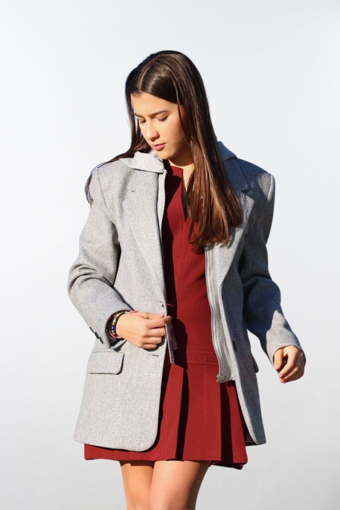 Mujer usando blazer largo gris con capucha, de frente