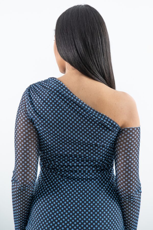 Detalle de escote y textura de la falda tableada del vestido negro trasera superior